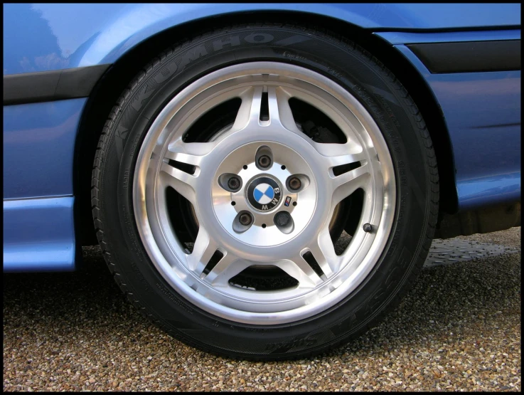 the wheel of a blue bmw is pictured