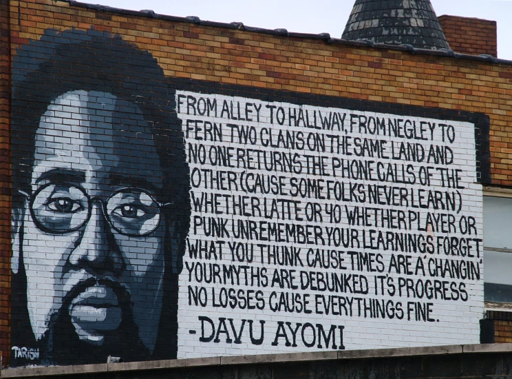 a mural on a brick building with words written in different languages