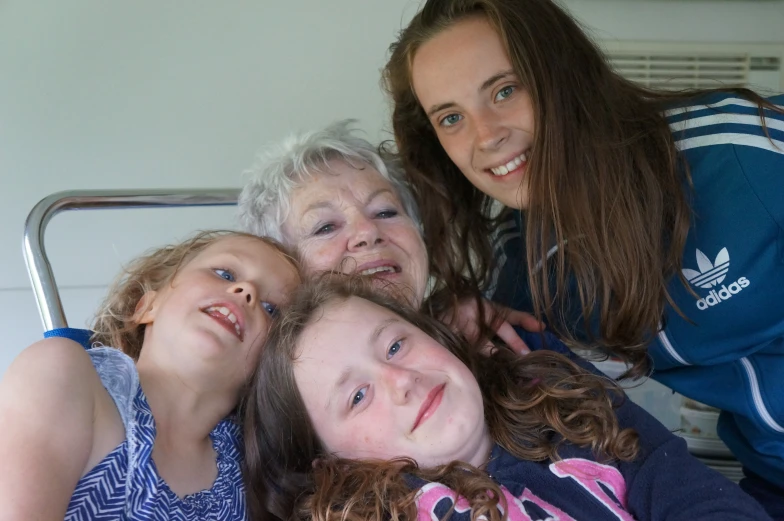 three girls sitting on a bed with their mother