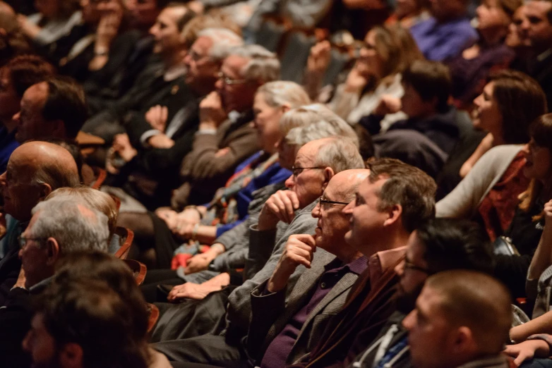 an audience in an auditorium watching soing being filmed