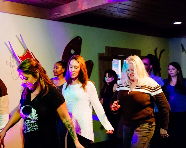 two ladies dancing in front of a crowd at a nightclub