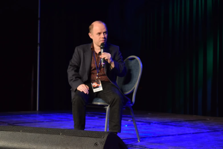 man sitting on a chair at an indoor event