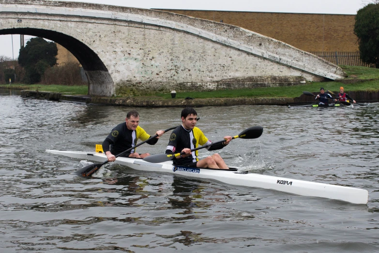 two men are rowing down the river