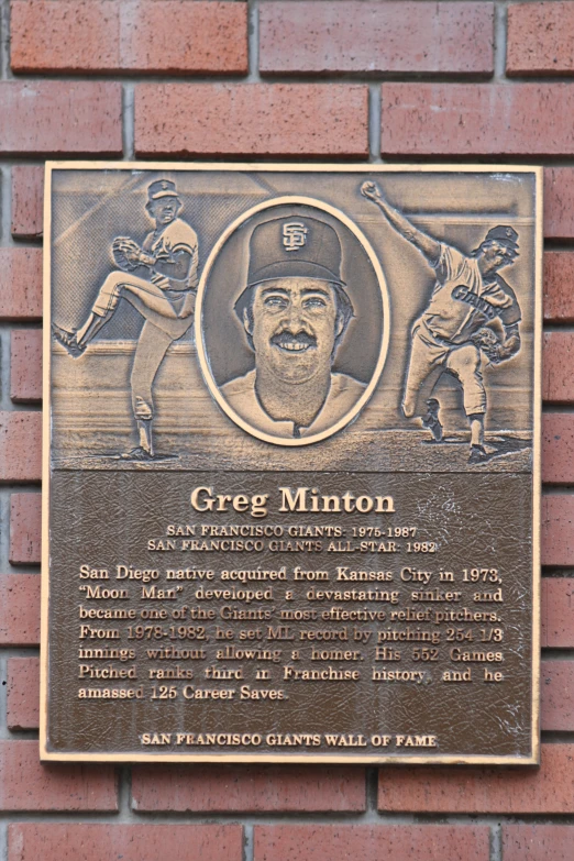 a baseball plaque mounted on the side of a brick wall