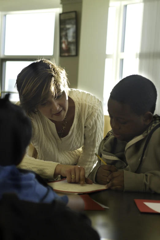 a woman that is sitting in front of two children