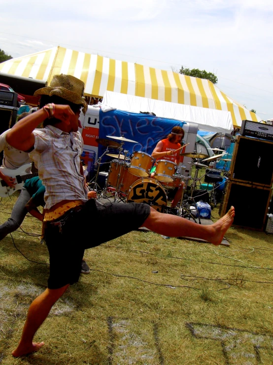 a man doing yoga in front of a tent