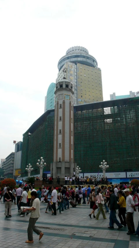 a crowd of people walking in an area with buildings