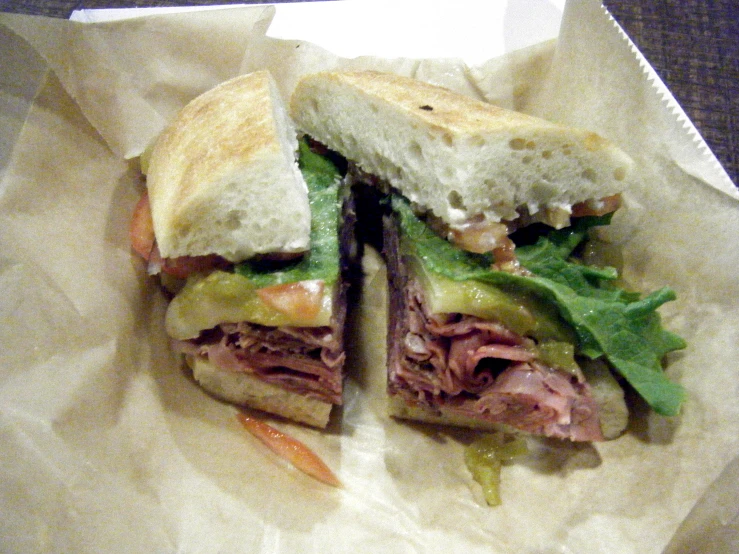 a meat and vegetable sandwich cut in half