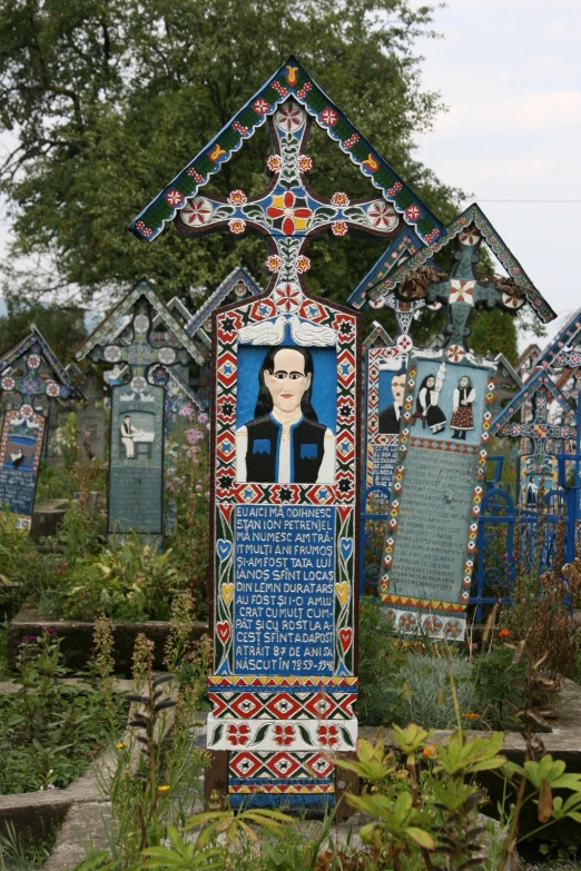 a plaque made with tiles in front of a garden