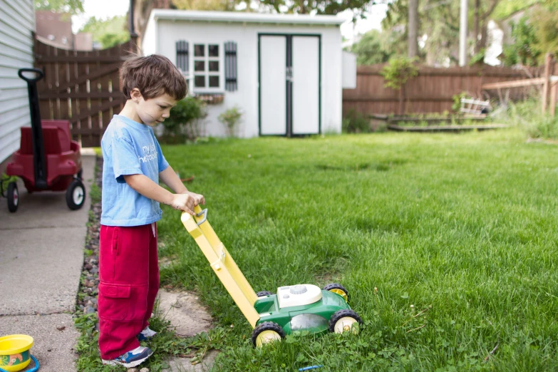 the little boy is playing outside with his toys