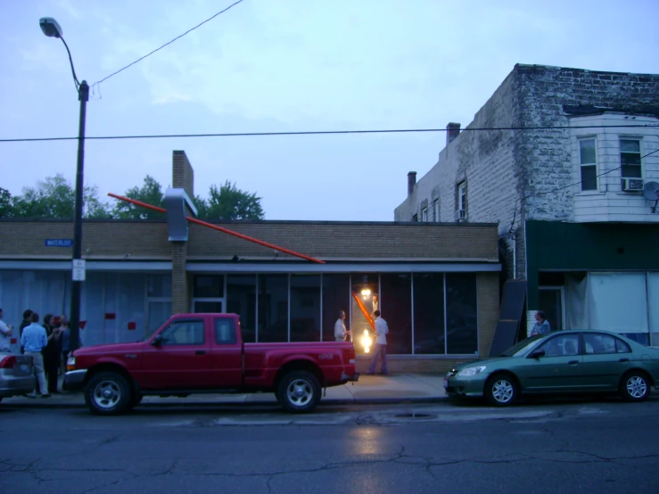 red truck sitting on the street near a house