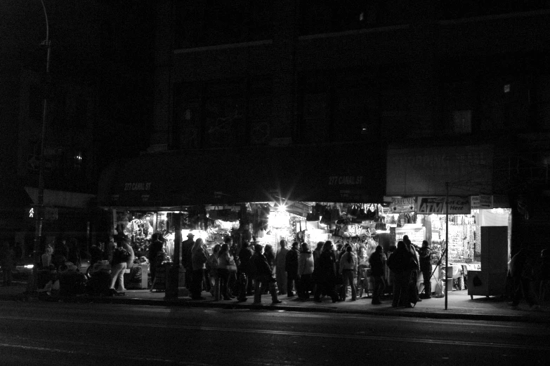 a group of people standing around outside in the dark