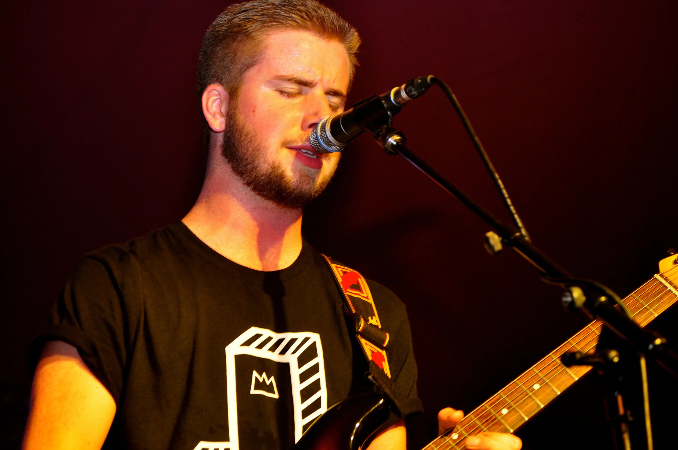 a man is playing a guitar while singing into a microphone