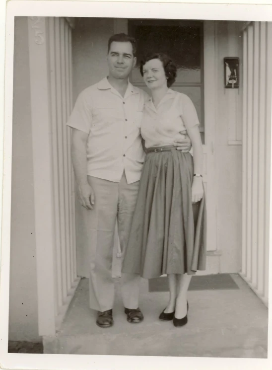 a woman standing next to a man while wearing dress