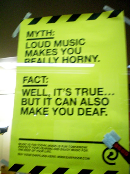 yellow sign on door with warning words for music makes you really 