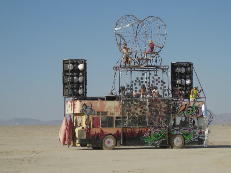 a truck parked on the sand with a lot of decorations on it