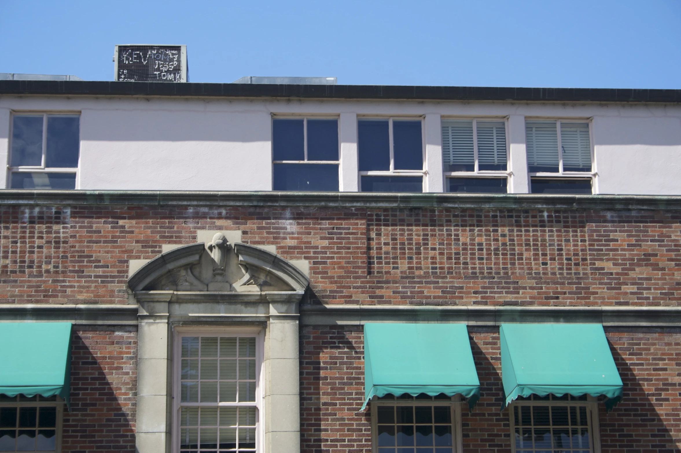 a red brick building with awnings and clock on top