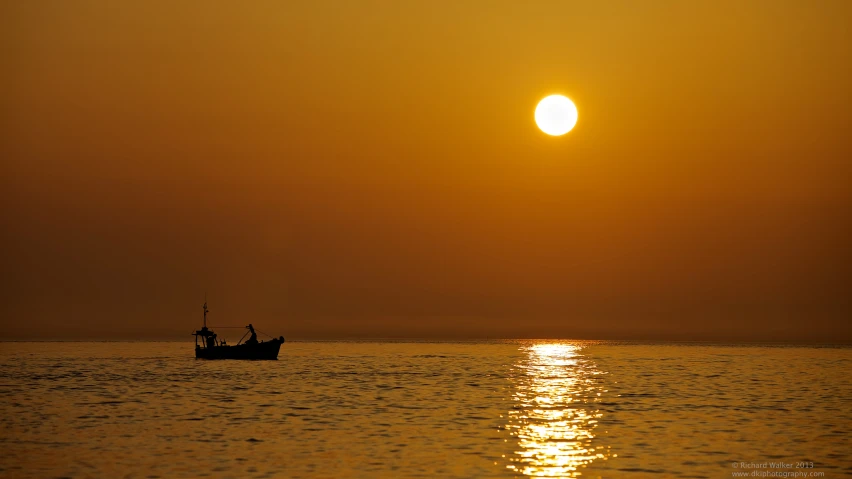 a large boat in the middle of a body of water under the sun