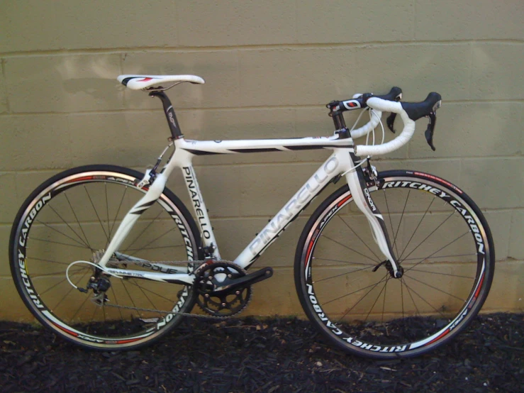 there is a white bicycle leaning against a wall