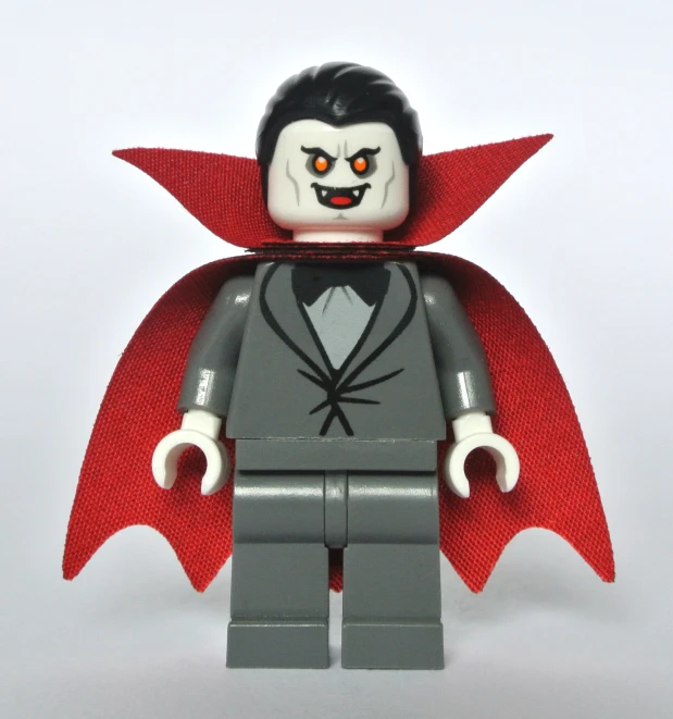 a lego figure wearing a red cape, black and grey suit and shirt