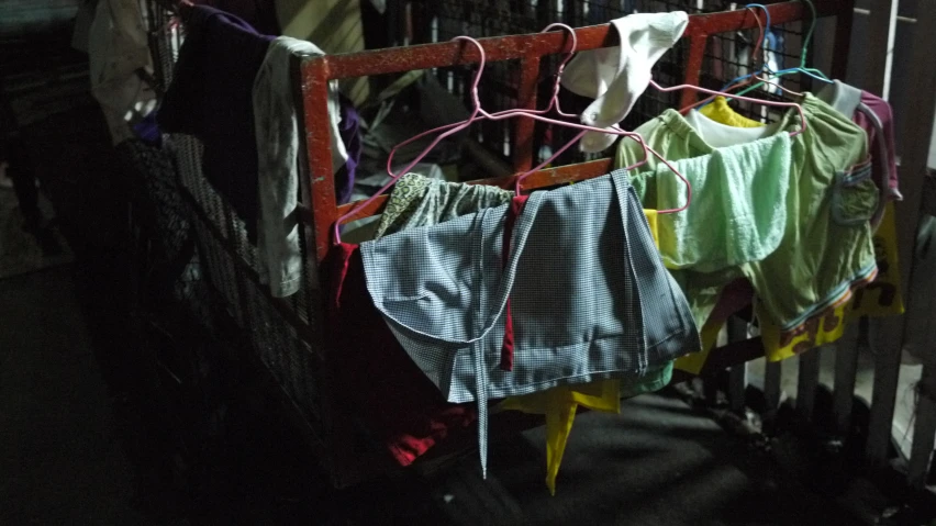 a rack in the hallway with laundry hanging on clothes