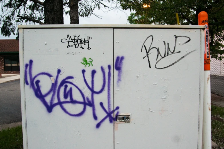 a couple of white refrigerators covered in graffiti