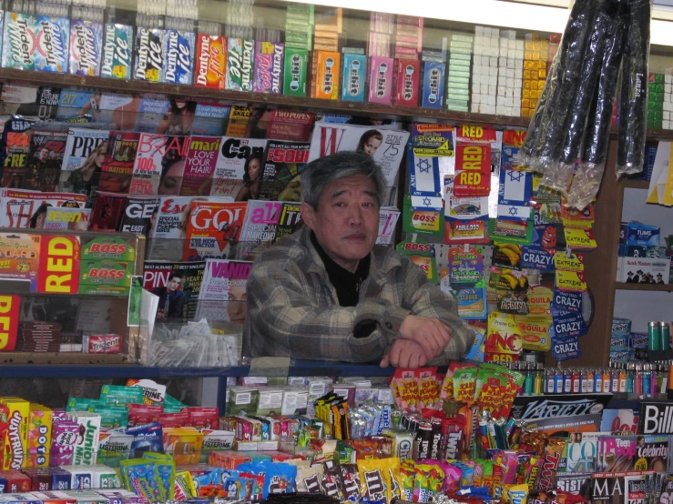 the man behind the counter is looking at his phone