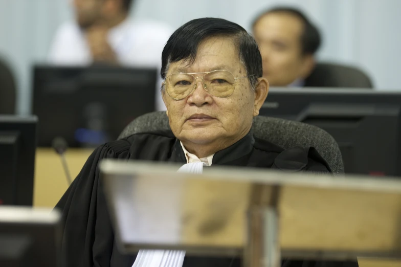 judge sitting at his desk in front of people