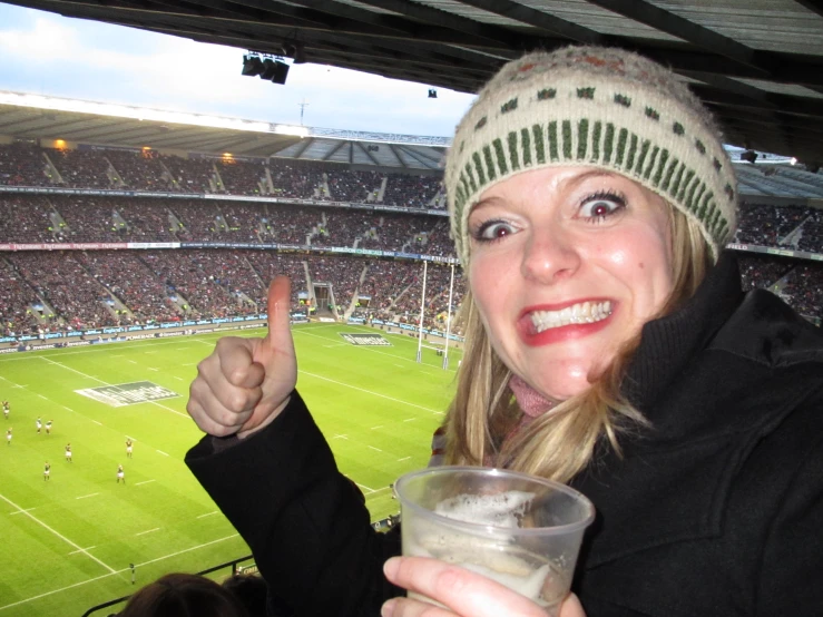 a lady giving the v sign with her drink