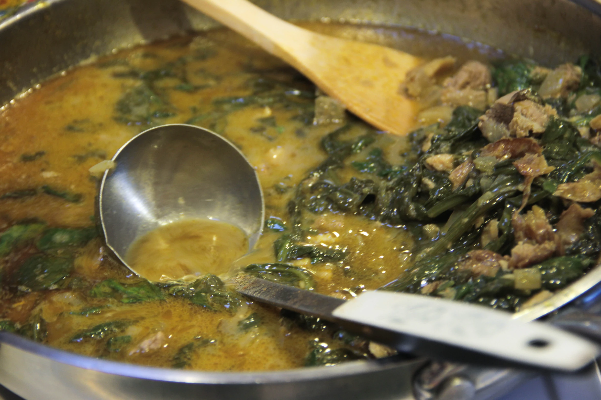 a ladle and ladle sit in a pot of soup