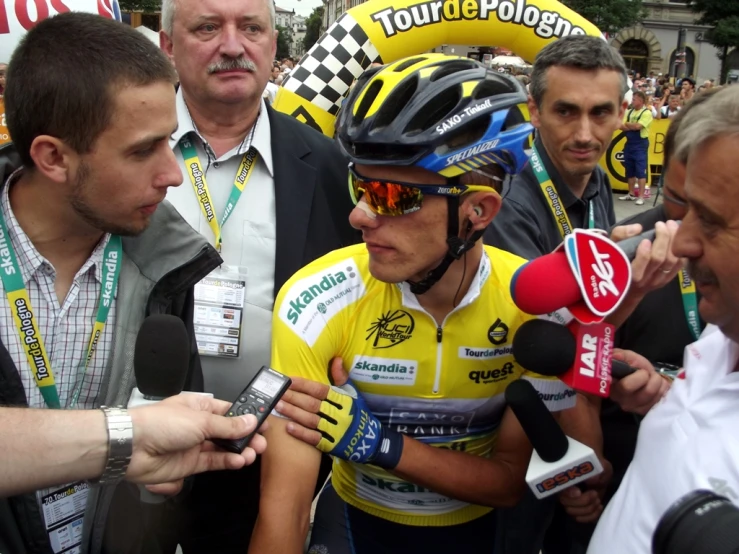 a man with his helmet on while talking to media