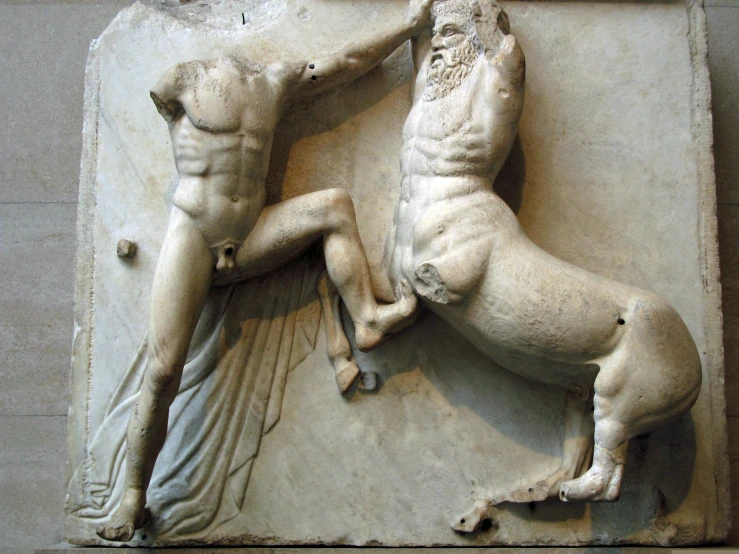 an ancient sculpture depicting two men fighting each other