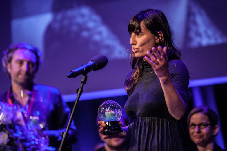 a woman holding a globe on a stage