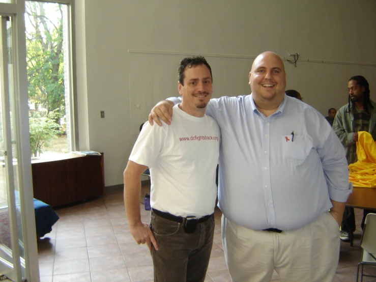 two men standing next to each other smiling