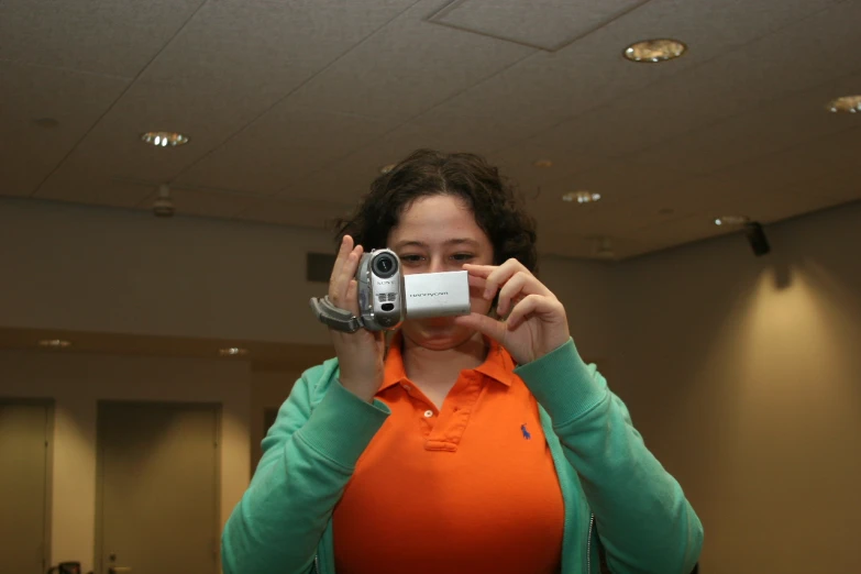 a woman standing in front of a camera taking a po