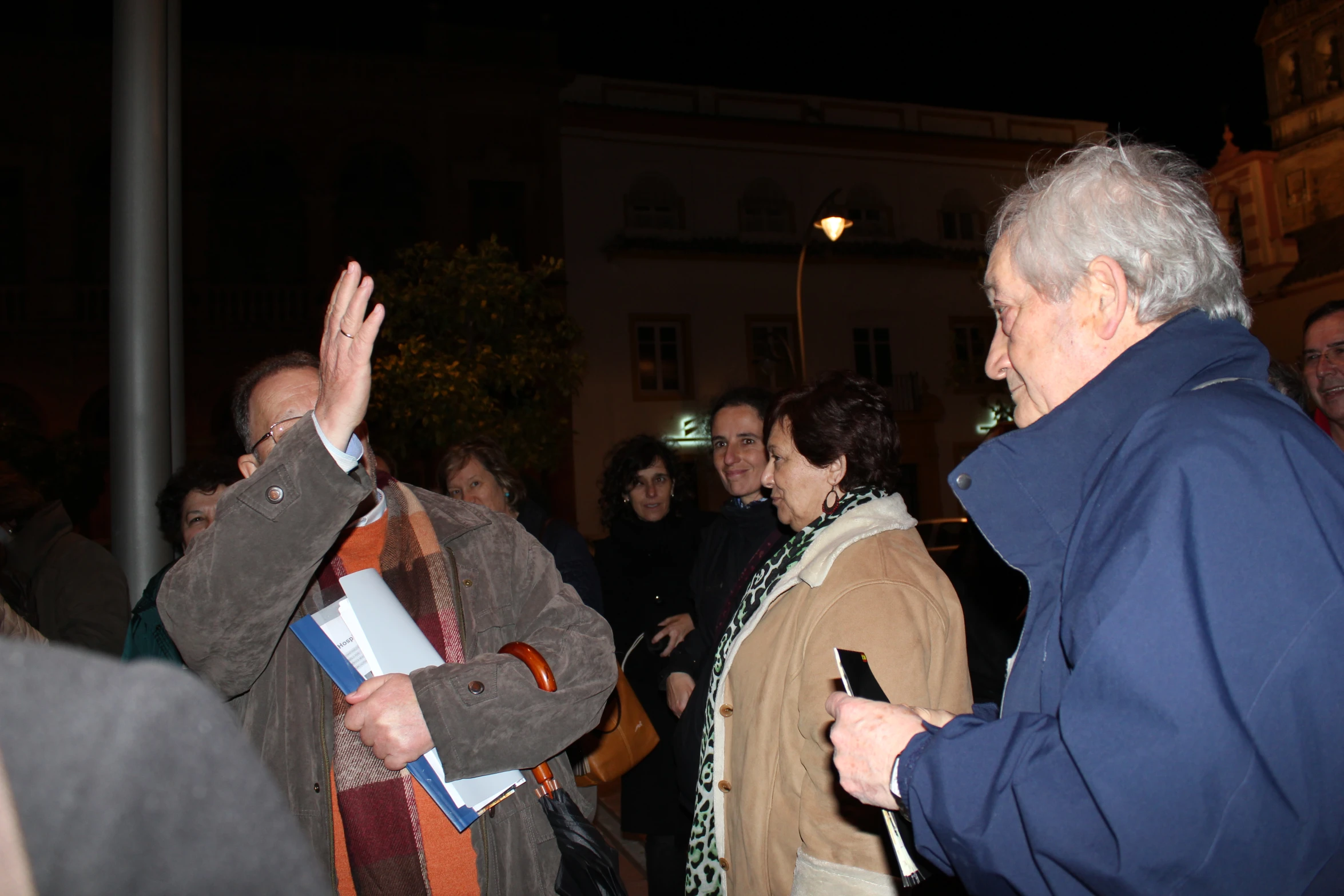 two men in dark jackets greeting each other