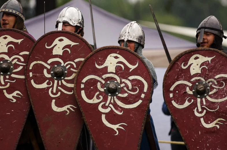 the men are dressed in costumes as they carry their shield and shields