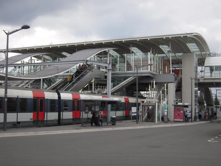 a passenger train waiting in front of a train station