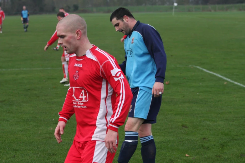 a group of men play soccer in a field