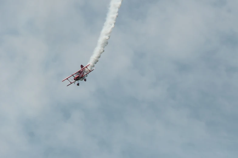 a airplane is flying in the sky with smoke coming out