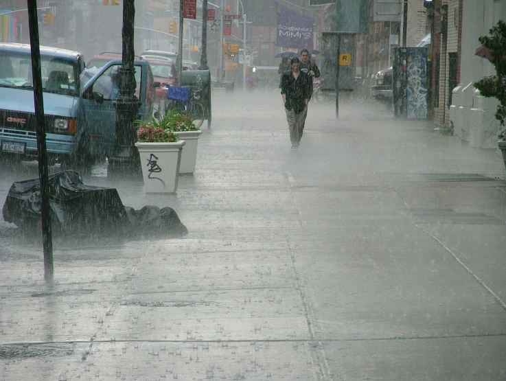 a sidewalk and street where two people are walking