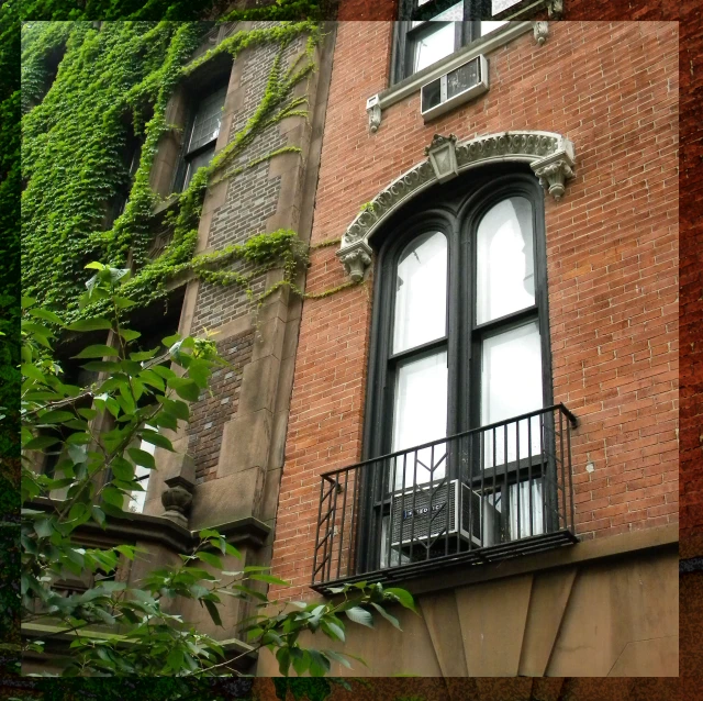 a tall building has an iron balcony and windows