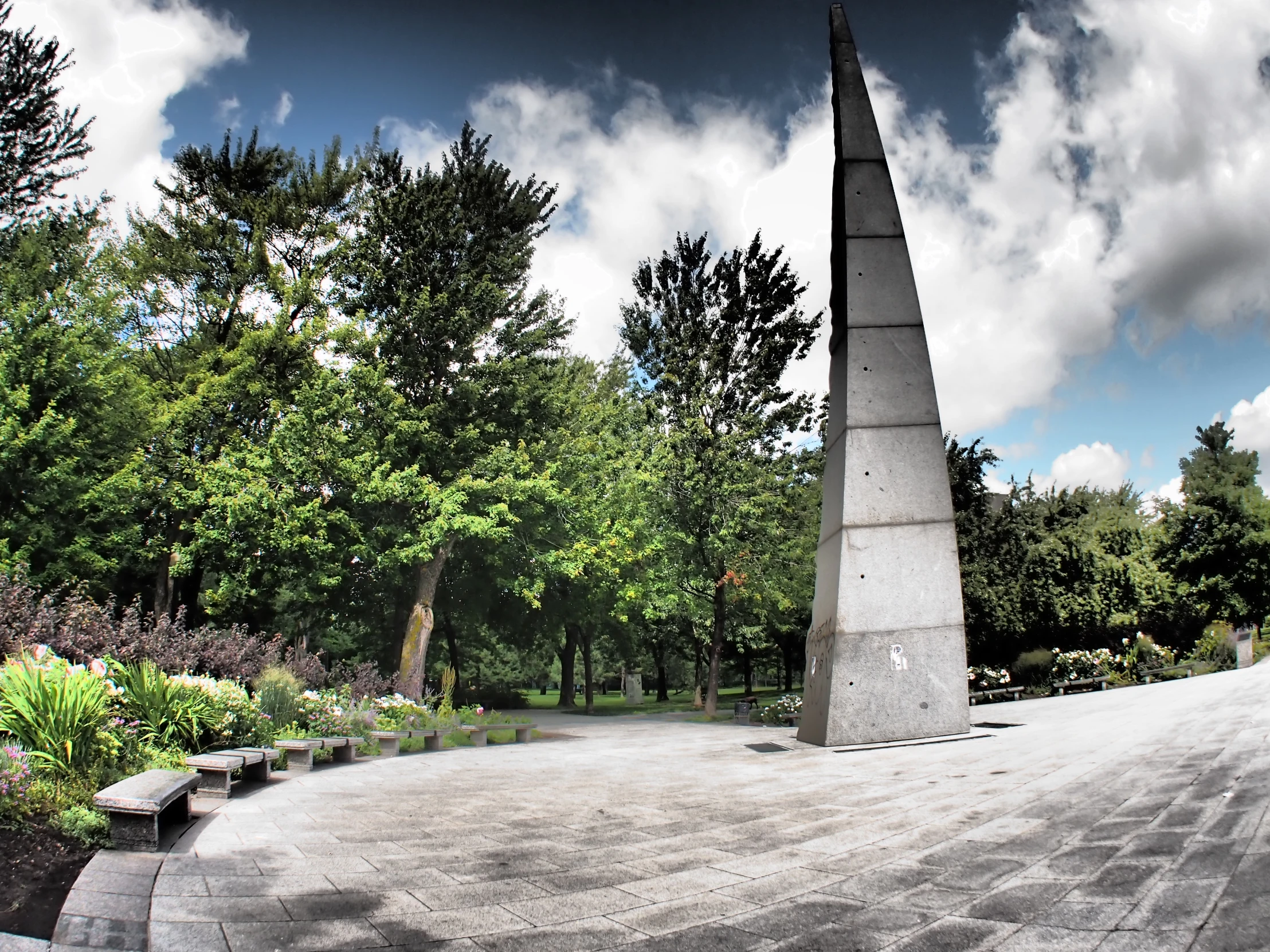 a concrete monument in a park with benches