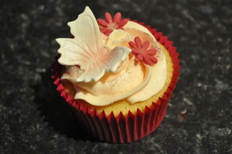 a cupcake decorated with cream frosting and flowers