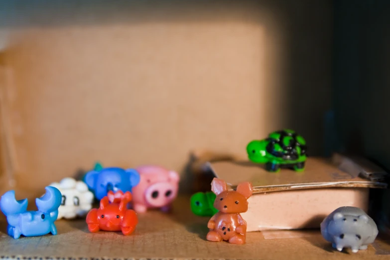 there is an open box with toy pigs and rhinos