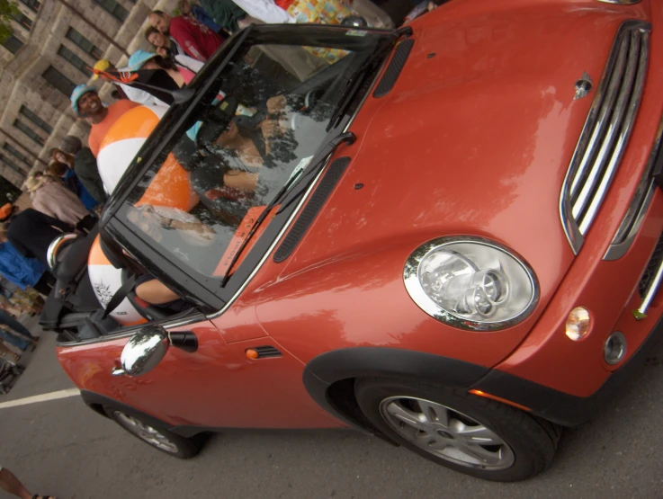 an older lady is looking out of the small car