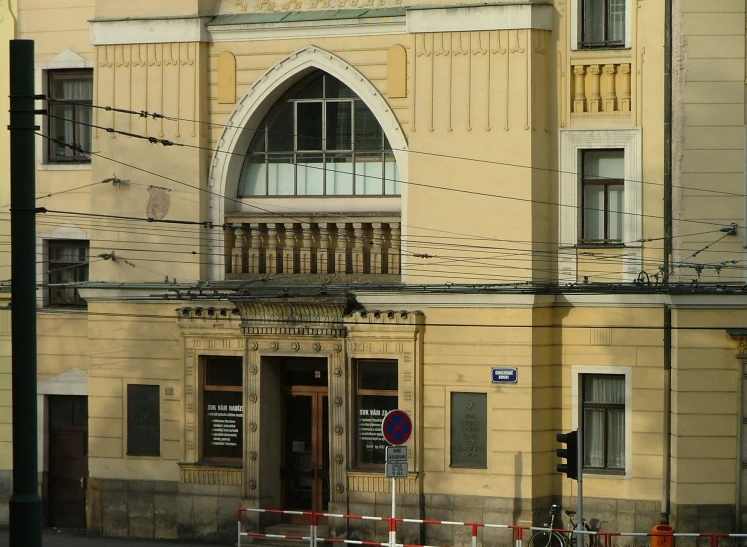 a large building is sitting beside a street with two cars parked next to it