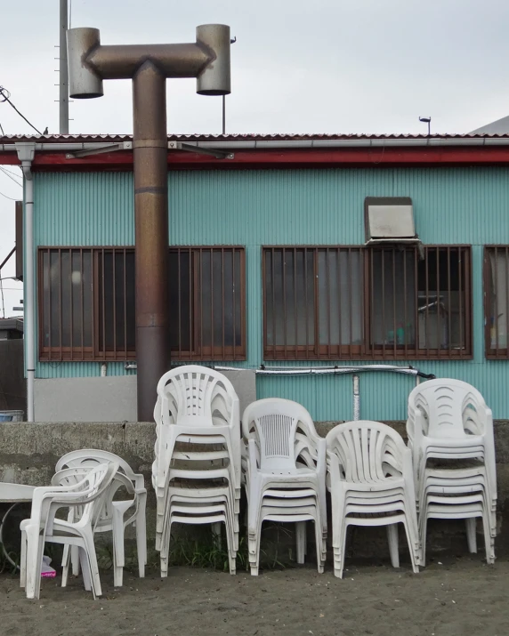 many white chairs are set up in front of a house