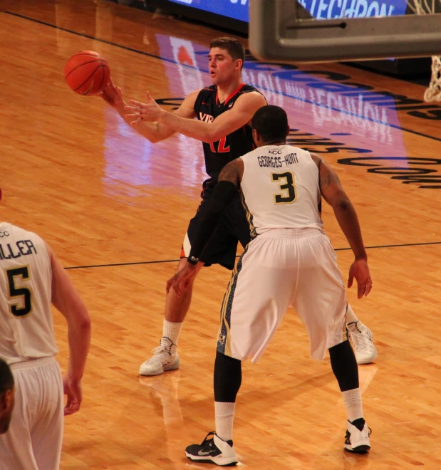 the man has his arm in the air to block the ball from him