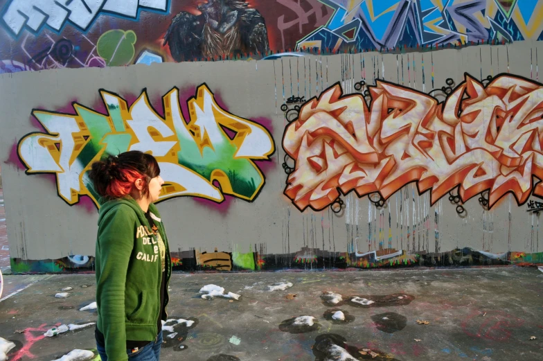 two young people standing in front of some grafitti